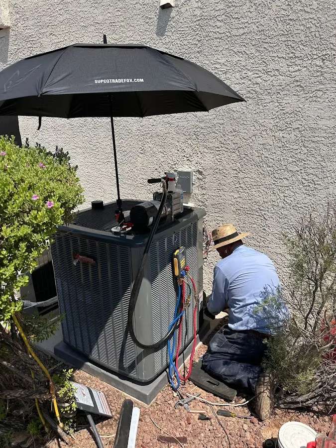 HVAC technician performing outdoor AC maintenance in Ghent
